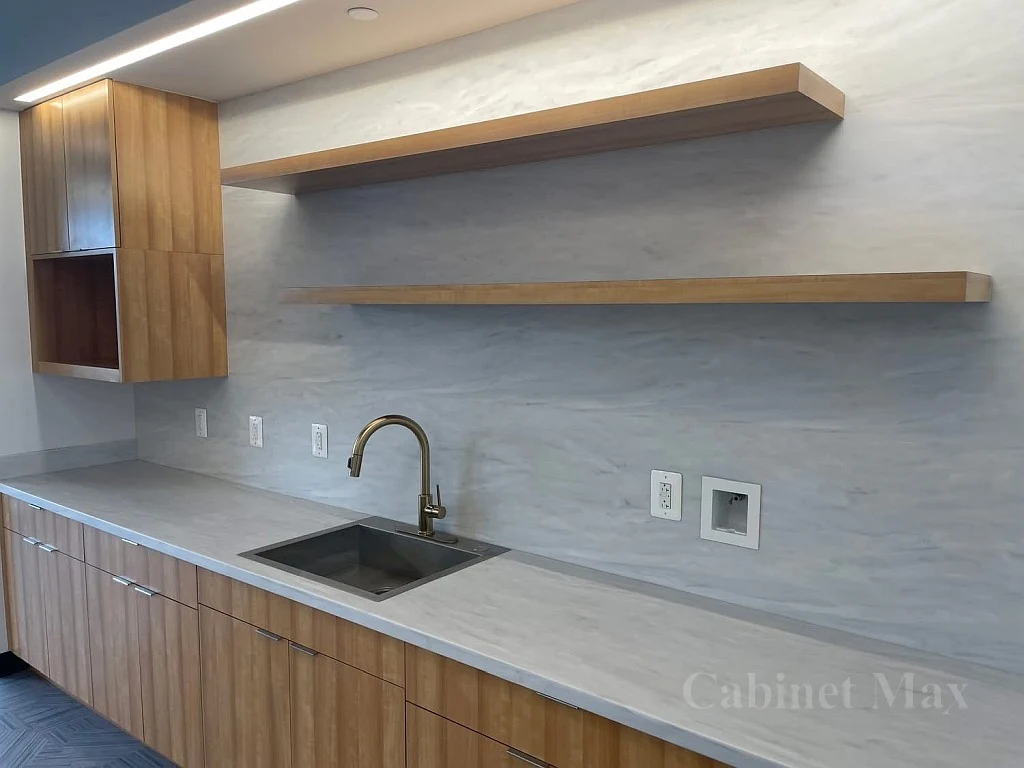 Wood cabinetry and floating shelves with a continuous counter and sink