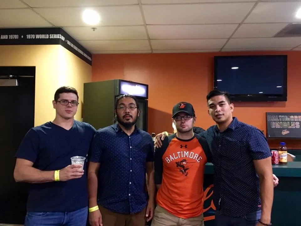 Four people from the Cabinet Max group posing together at a baseball outing