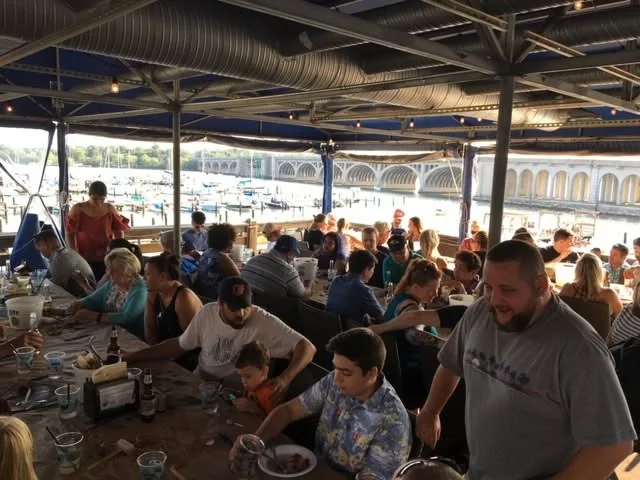 Cabinet Max gathering around long tables for a waterfront crab feast